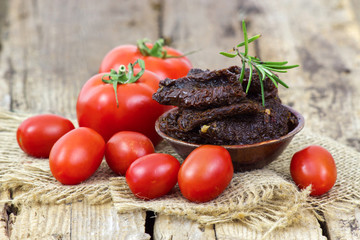 fresh and dried tomatoes on wooden background