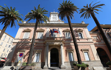 The city hall of Ajaccio framed by palm fronds, Corsica island, France.