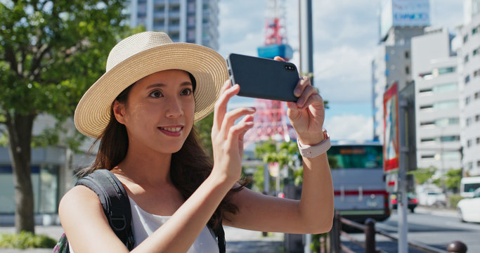 Woman travel in tokyo and take photo in the city