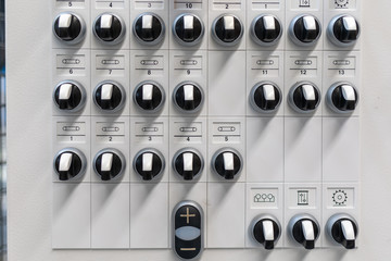 at one control panel there are many black switches next to each other and among each other