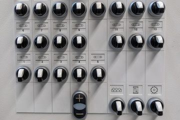at one control panel there are many black switches next to each other and among each other