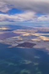 Great Salt Lake Utah Aerial view from airplane looking toward Oquirrh Mountains and Antelope Island, Tooele, Magna, with sweeping cloudscape. United States.