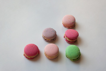 Colorful macaroon cakes triangle shaped composition isolated on white background