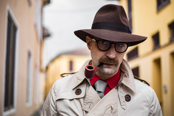 Vintage detective smoking a pipe outdoor in a grungy environment