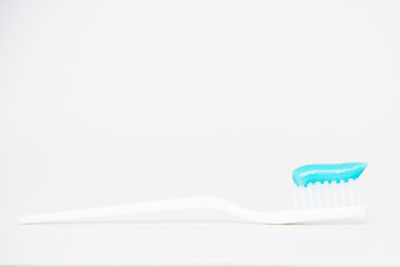 Toothbrush with toothpaste on white background