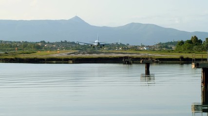 Passenger airplane landing on the runway at airport in sunset. Greece. 4K