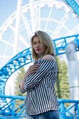 Young caucasian girl in striped shirt walking in park on vacation day