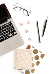 White desk with laptop, notepads, glasses and stationery