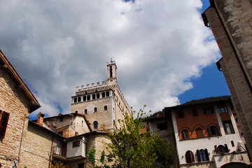 Palazzo dei Consoli (Consulate Palace) among clouds, a medieval building symbol of Gubbio in Umbria, towering above the city historic center