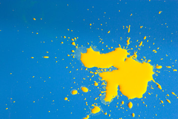 A BLOB of yellow paint on a blue background