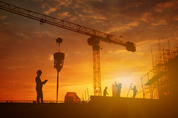 Silhouette of inspector working at construcktion on twilight background.