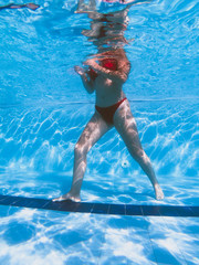 Underwater view from a girl with a red bikini in a pool