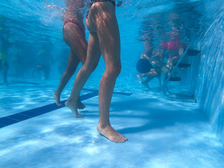 Underwater view from two girls in bikini standing in a pool