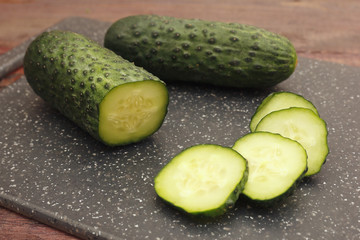 Chopped fresh cucumber on cutting board on a wooden table
