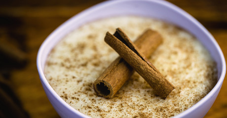 Creamy rice pudding sprinkled with cinnamon, typical Brazilian dessert.