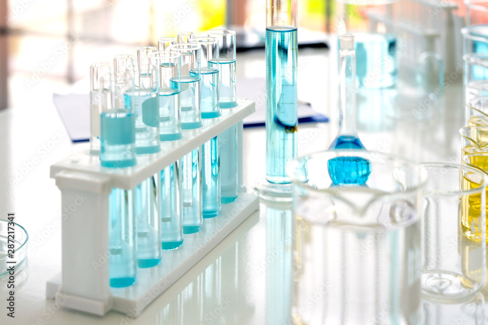 Wall mural flask in scientist hand with test tubes in laboratory