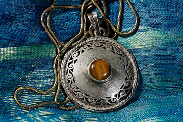 silver medallion with ancient tiger eye stone