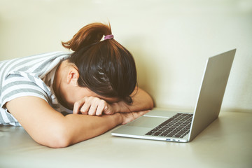 Women in casual dress sleeping on sofa bed with laptop computer. Tired or sleepy concept.