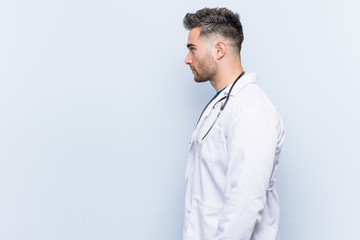 Young handsome doctor man gazing left, sideways pose.