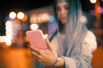 Woman holding smart phone and give your number at night city