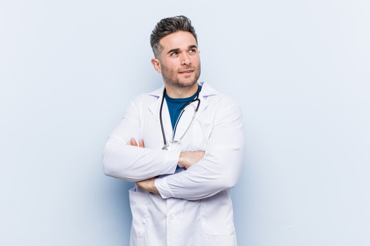 Young handsome doctor man smiling confident with crossed arms.