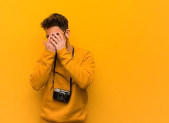 Young photographer man embarrassed and laughing at the same time