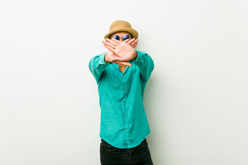 Young hispanic man wearing a summer clothes doing a denial gesture