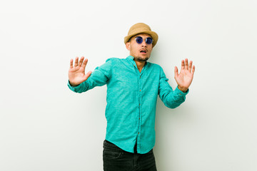 Young hispanic man wearing a summer clothes being shocked due to an imminent danger