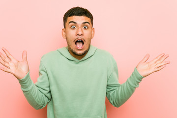 Fototapeta premium Young hispanic sport man celebrating a victory or success, he is surprised and shocked.