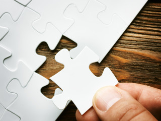 Hand with missing jigsaw puzzle piece. Business concept image for completing the final puzzle piece