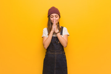 Young hipster woman praying very happy and confident