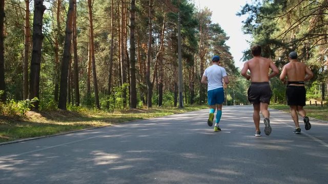 Unrecognizable runners jogging in the park. Active sport concept 4k