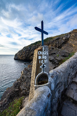 Cross on the stairway climbing up to the hermitage of San Juan de Gaztelugatxe, Bermeo, Basque Country, Spain