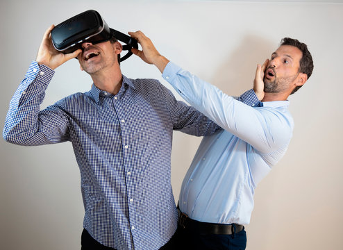 dos hombres adultos luchando para jugar con las gafas de realidad virtual