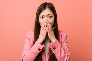 Young business chinese woman wearing pink suit scared and afraid.