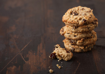 Homemade organic oatmeal cookies with raisins and apricots on dark wooden background. Space for text