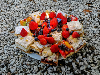 Kuchenplatte mit verschiedenen Kuchen und einer kleinen Kerze.