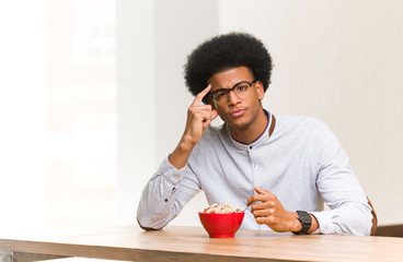 Fototapeta na wymiar Young black man having a breakfast thinking about an idea