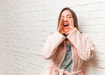 Young woman wearing pajama shouting something happy to the front