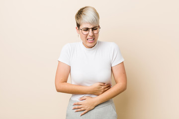 Obraz premium Young authentic natural woman wearing a white shirt sick, suffering from stomachache, painful disease concept.