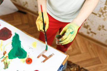 little girl paint with hands on the table
