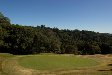Fototapeta na wymiar Campo de golfe com árvores e céu azul
