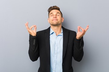 Young handsome caucasian man relaxes after hard working day, she is performing yoga.