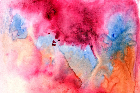 Beautiful abstract smudges of orange, red, blue and pink colors in hand painted watercolor background design