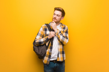 Young redhead student man doubting and confused