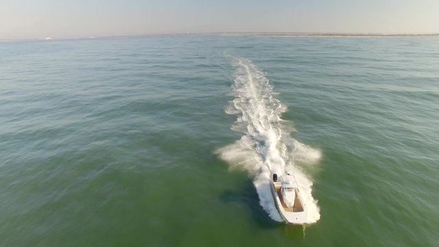In Front Aerial Shot Chasing a Skipping Twin Prop Speed Boat Through the Tropical Emerald Green Ocean Waves, part of a series