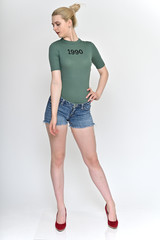 Full length vertical Portrait of a cute blonde student girl, a young woman in a green T-shirt and blue shorts with beautiful curly hair on a white background in various poses.