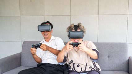 Senior asian couple playing virtual reality headset with happiness emotion, retirement lifestyle and technology