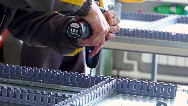 Drill screwdriver workflow creation of metal parts. male metal worker using drillpress. Close up