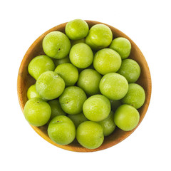 heap green cherry-plum in wooden cup isolated on white background. top view